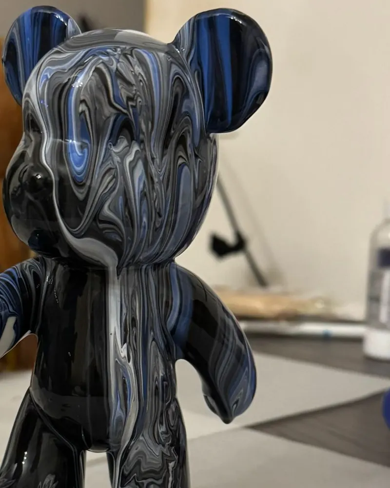 Blau-schwarz marmorierte Bärenfigur auf dem Arbeitstisch